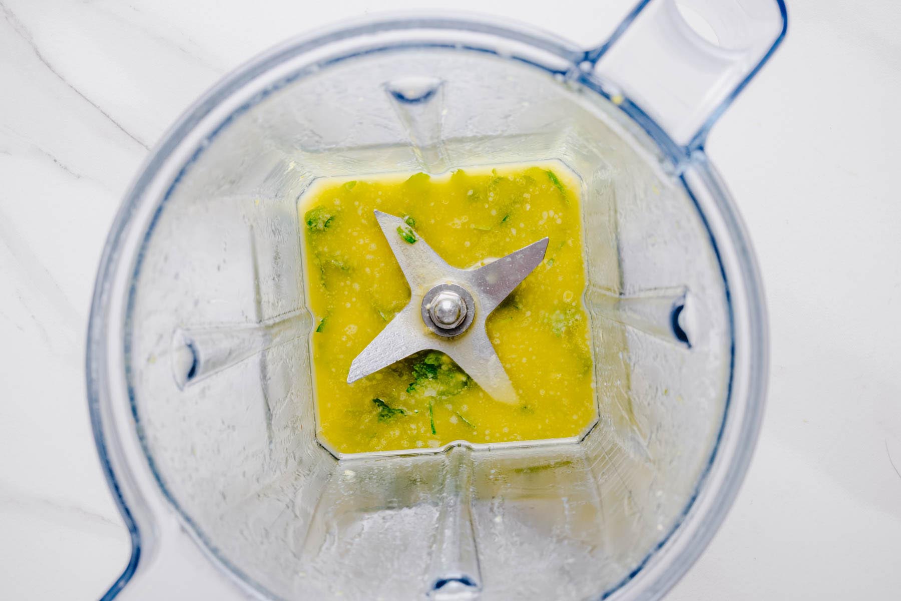Blended lemon herb sauce in a blender viewed from above.