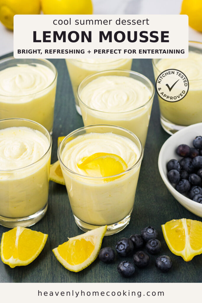 Six glasses of creamy lemon mousse are arranged on a tabletop and garnished with lemon slices, surrounded by fresh lemon wedges and blueberries. The Pinterest pin includes the text "Cool Summer Dessert Lemon Mousse – Bright, Refreshing + Perfect for Entertaining." This vertical Pinterest pin features a homemade lemon mousse recipe from Heavenly Home Cooking.