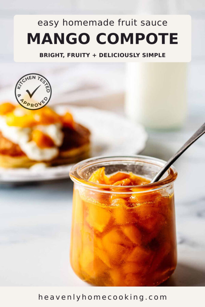 A glass jar filled with chunky homemade mango compote sits on a countertop with a spoon inside, while pancakes topped with whipped cream and mango compote are softly blurred in the background. The Pinterest pin includes the text "Easy Homemade Fruit Sauce Mango Compote – Bright, Fruity + Deliciously Simple." This vertical Pinterest pin features a homemade mango compote recipe from Heavenly Home Cooking.