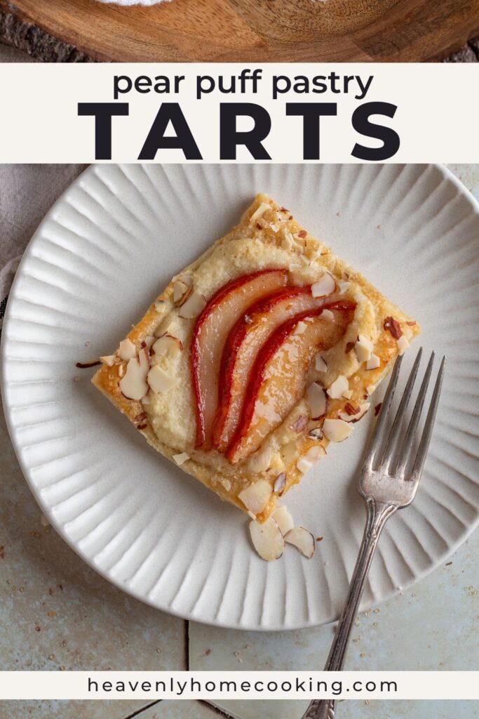 A flaky pear puff pastry tart topped with creamy almond filling, thinly sliced red pears, and toasted sliced almonds is served on a white plate with a fork. This vertical Pinterest pin features a homemade pear puff pastry tarts recipe from Heavenly Home Cooking.