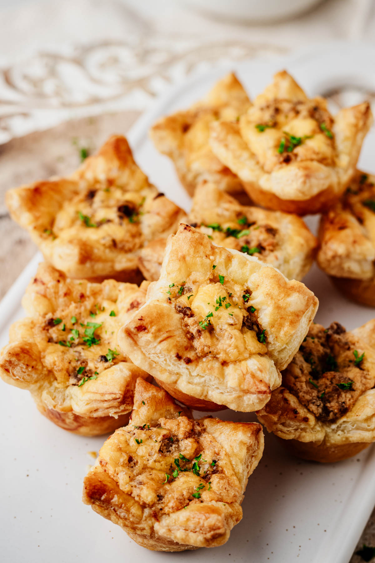 Close-up of golden sausage puff pastry cups showing the flaky layers and creamy Italian sausage filling.