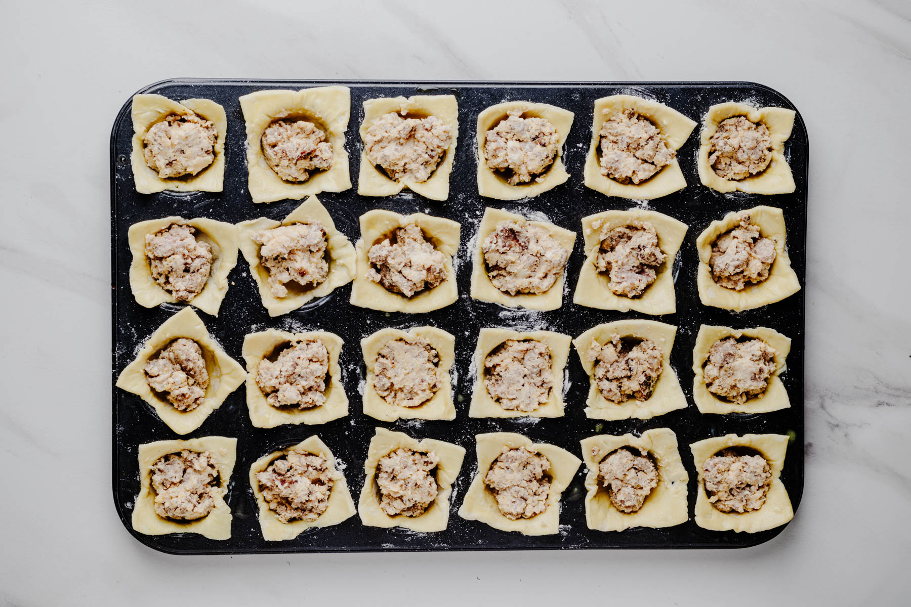 Puff pastry cups filled with small heaping spoonfuls of creamy Italian sausage filling.