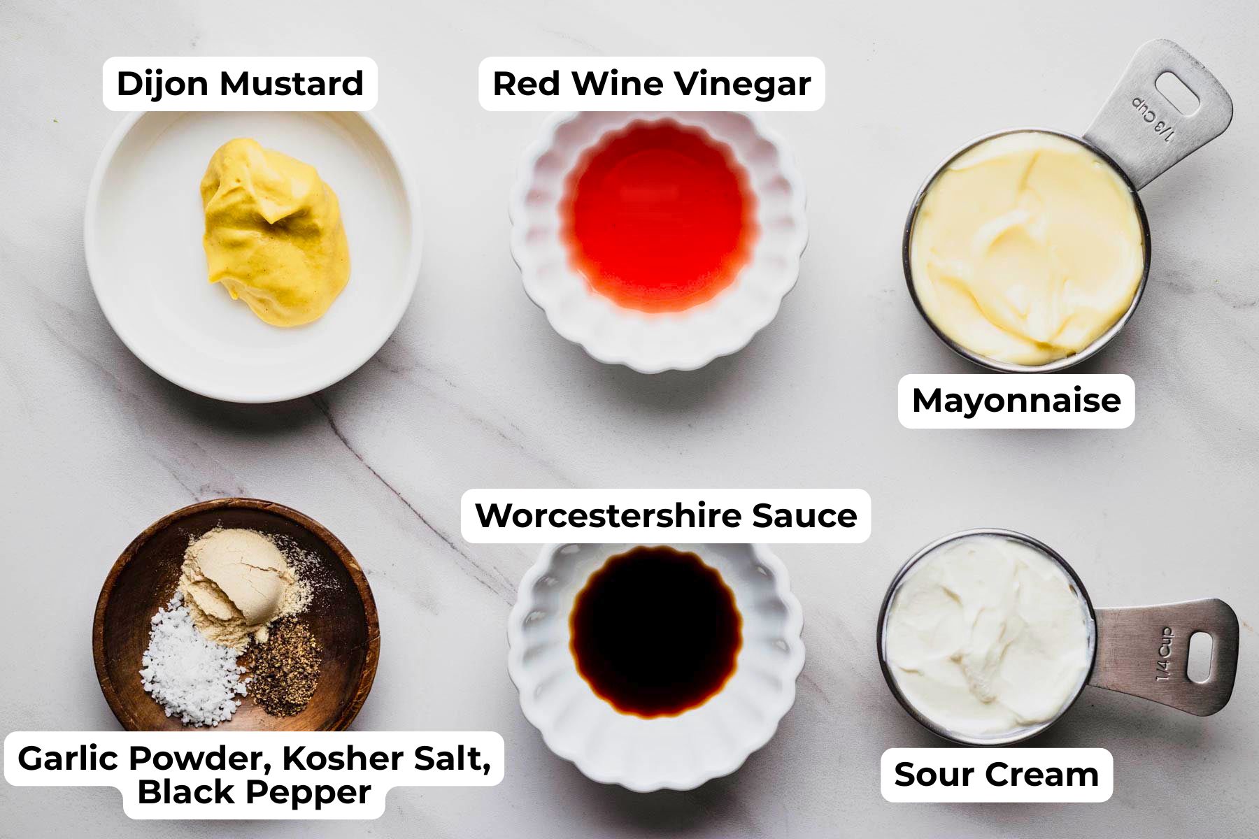 Ingredients for creamy steakhouse dressing arranged on a countertop, including Duke's mayonnaise, sour cream, Dijon mustard, red wine vinegar, Worcestershire sauce, garlic powder, kosher salt, and black pepper. Process photo for a homemade Steakhouse Salad recipe from Heavenly Home Cooking.