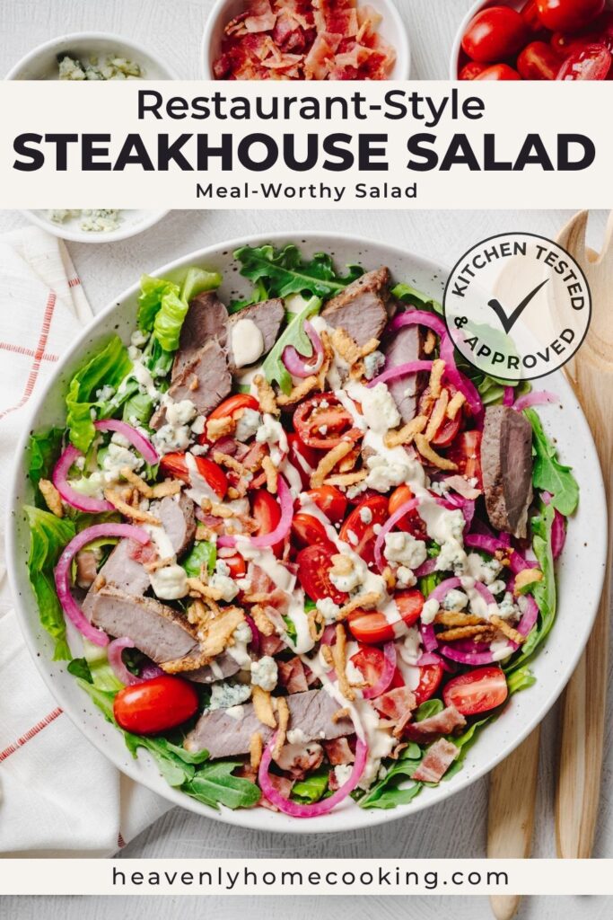 A vertical Pinterest pin showing a restaurant-style steakhouse salad topped with sliced steak, crisp lettuce, arugula, cherry tomatoes, quick pickled red onions, bacon, blue cheese crumbles, crispy fried onions, and creamy dressing. The pin is titled "Restaurant-Style Steakhouse Salad," includes the subtitle "Meal-Worthy Salad," features the Heavenly Home Cooking Kitchen Tested & Approved badge, and displays the Heavenly Home Cooking website at the bottom.