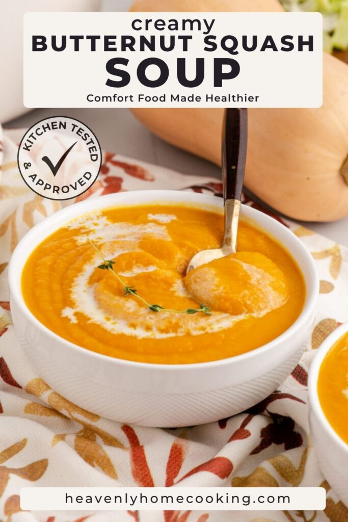 Creamy butternut squash soup served in a white bowl with a swirl of cream and fresh thyme, surrounded by whole butternut squash. The Pinterest pin reads "Creamy Butternut Squash Soup" with the subtitle "Comfort Food Made Healthier," and includes a Kitchen Tested & Approved badge and Heavenly Home Cooking branding.
