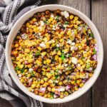 Overhead view of Hatch chile corn salad with charred corn, roasted green chiles, Cotija, red onion, and cilantro.