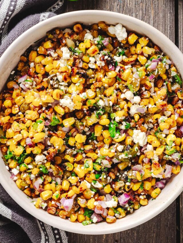 Overhead view of Hatch chile corn salad with charred corn, roasted green chiles, Cotija, red onion, and cilantro.
