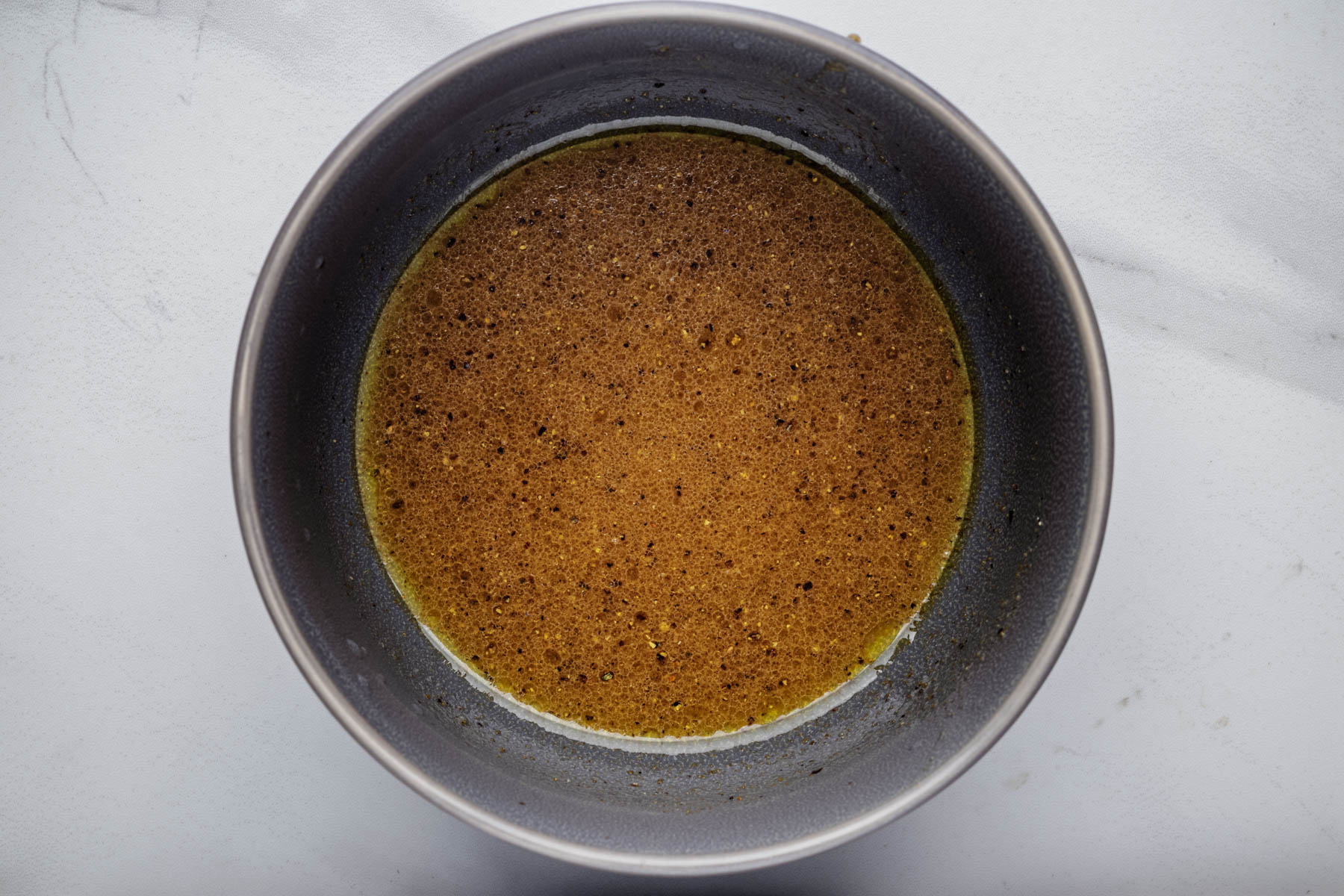 Lime dressing with olive oil, honey, cumin, garlic powder, salt, and black pepper in a small bowl.