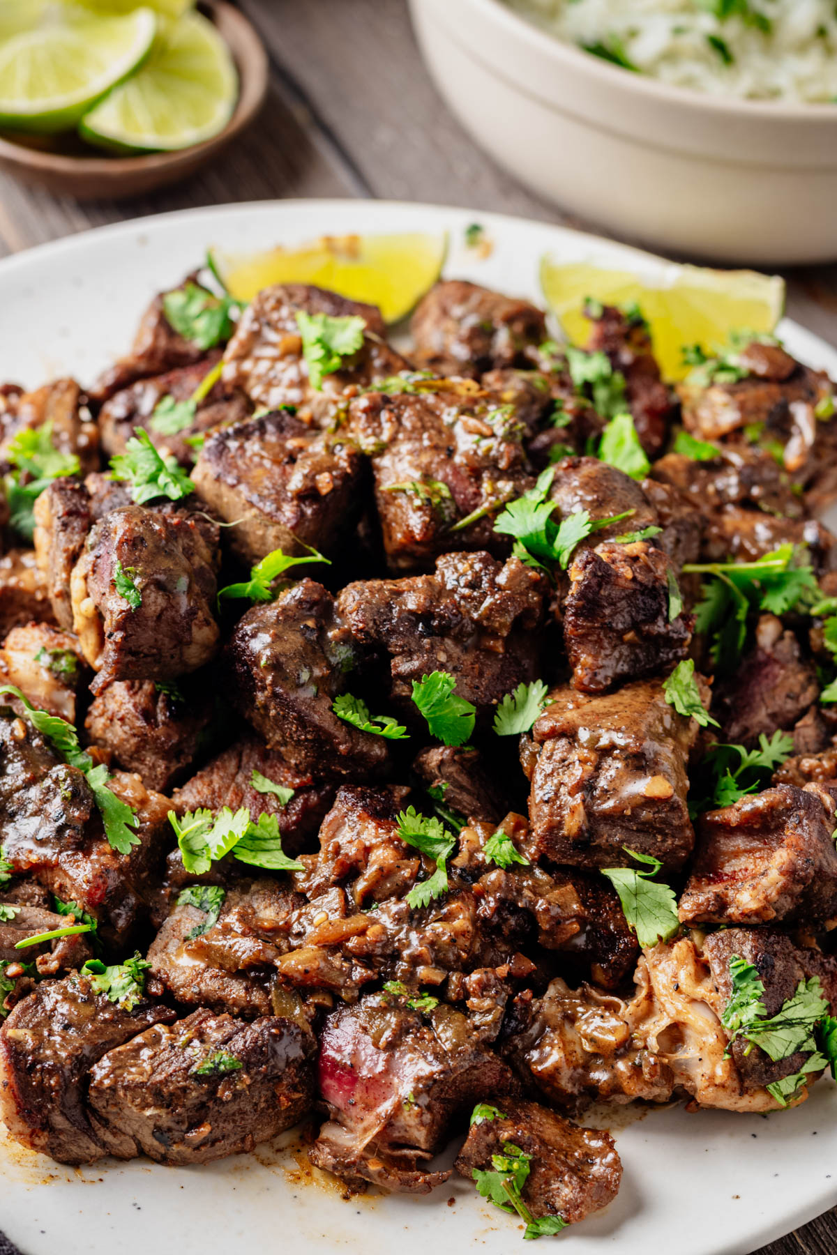 Close-up of browned Hatch chile steak bites coated in chile garlic butter and garnished with fresh cilantro.