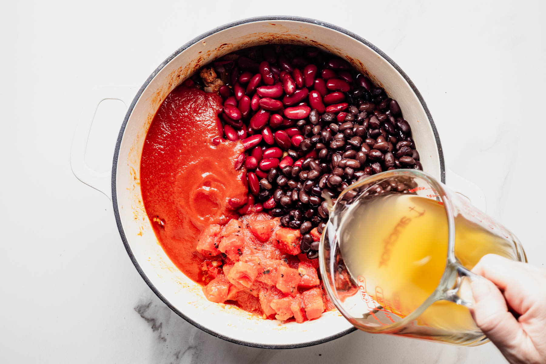 Kidney beans, black beans, tomatoes, tomato sauce, and chicken broth added to the turkey chili.