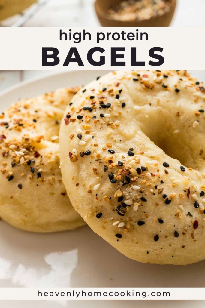 Pinterest pin for high-protein bagels showing a close-up of homemade everything bagels on a white plate. The text overlay reads "High Protein Bagels." The bagels have a golden crust and are topped with everything bagel seasoning, with Heavenly Home Cooking branding at the bottom.
