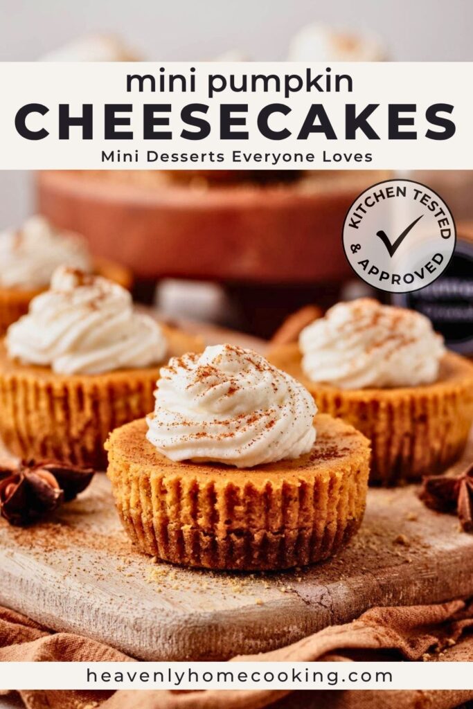 Mini pumpkin cheesecakes topped with swirls of whipped cream and a sprinkle of pumpkin pie spice, arranged on a rustic wooden board with warm fall spices in the background. The Pinterest pin reads "Mini Pumpkin Cheesecakes" with the subtitle "Mini Desserts Everyone Loves," and includes a Kitchen Tested & Approved badge and Heavenly Home Cooking branding.