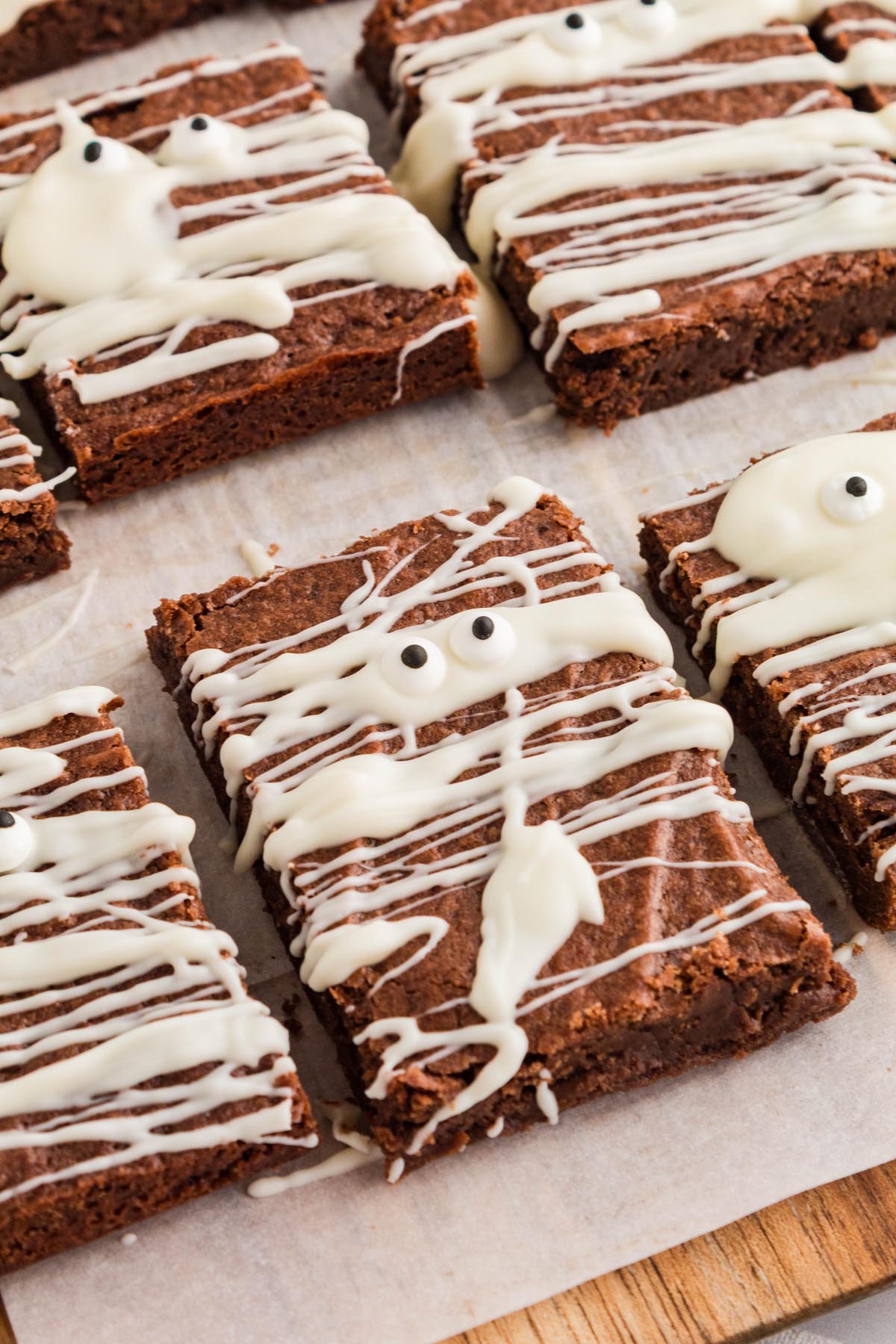 Close-up overhead view of mummy brownies with white chocolate drizzle and candy eyes.