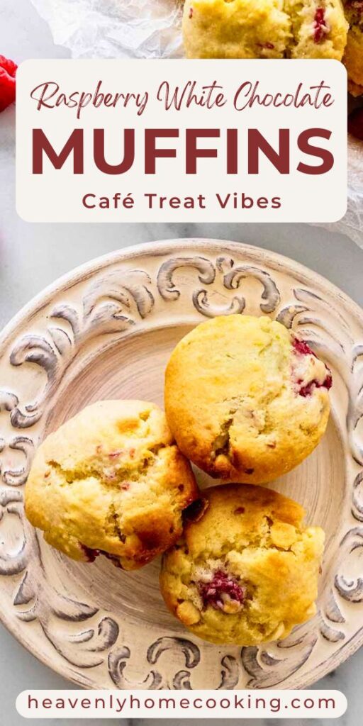 Raspberry white chocolate muffins with golden tops and pieces of raspberry and white chocolate, arranged on a decorative plate. Text reads “Raspberry White Chocolate Muffins – Café Treat Vibes.” Heavenly Home Cooking.