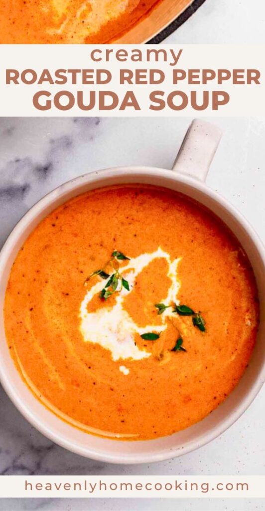 Overhead view of smooth roasted red pepper and Gouda soup garnished with cream and fresh herbs. This is a Pinterest pin for a Heavenly Home Cooking recipe.