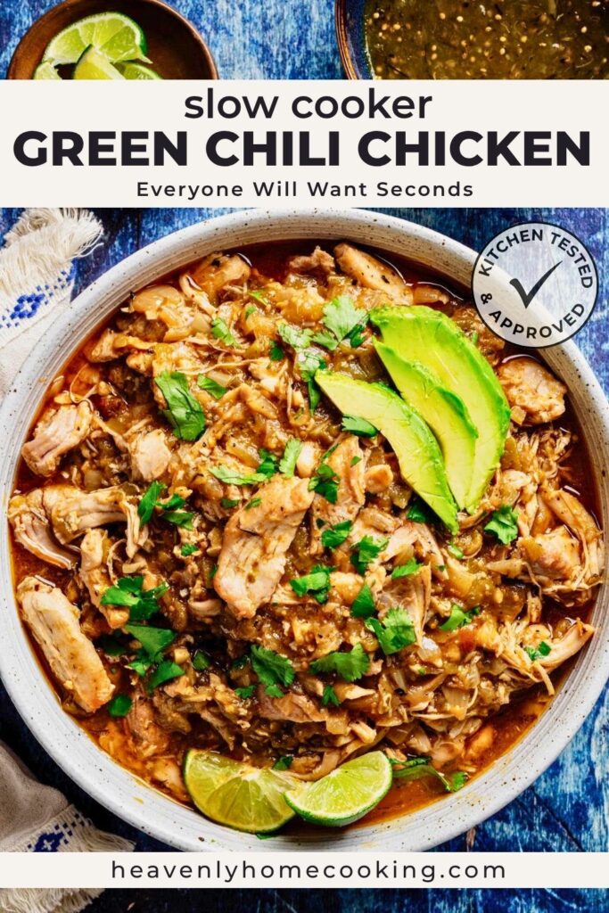 Vertical Pinterest pin for slow cooker green chili chicken featuring a bowl of tender shredded chicken in a savory green chili sauce, topped with fresh avocado slices, cilantro, and served with lime wedges. The text overlay reads "Slow Cooker Green Chili Chicken" with the subtitle "Everyone Will Want Seconds," and includes a Kitchen Tested & Approved badge and the Heavenly Home Cooking logo.