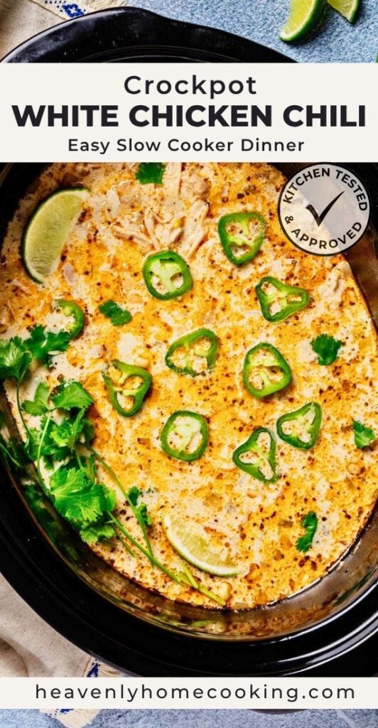 Vertical Pinterest pin for crockpot white chicken chili featuring a slow cooker filled with creamy white chicken chili topped with sliced jalapeños, fresh cilantro, and lime wedges. The text overlay reads "Crockpot White Chicken Chili" with the subtitle "Easy Slow Cooker Dinner," and includes a Kitchen Tested & Approved badge and the Heavenly Home Cooking logo.